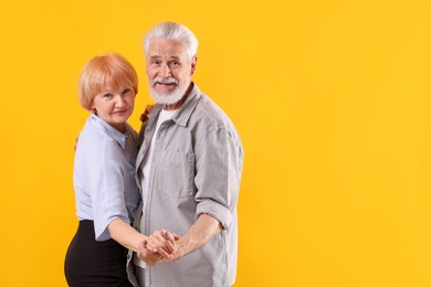 Photo of Lovely senior couple together on yellow background, space for text