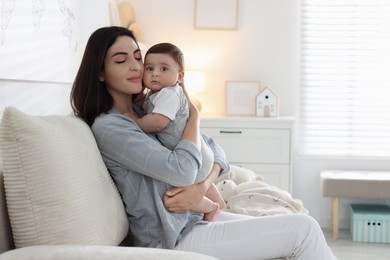Photo of Mother with her cute baby on sofa at home. Space for text