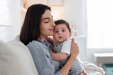 Photo of Mother with her cute baby on sofa at home