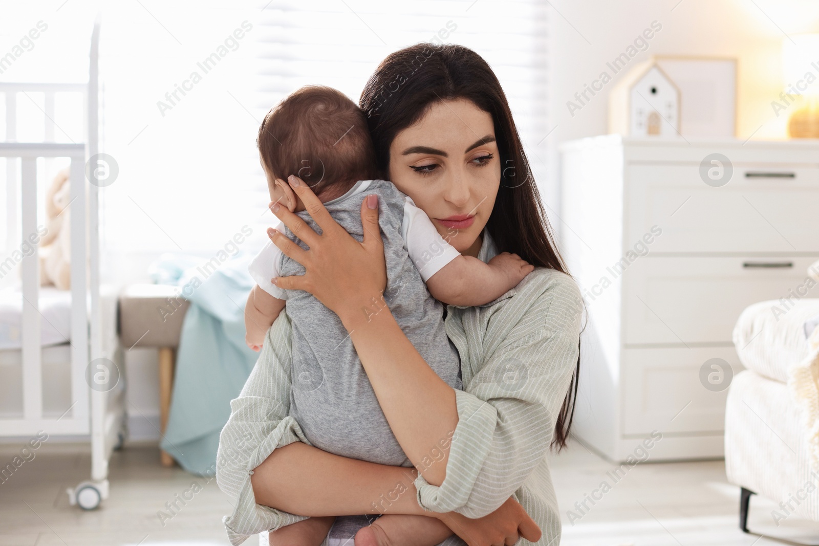 Woman suffering from postpartum depression with her little baby at home Photo of Woman suffering from postpartum depression with her little baby at home
