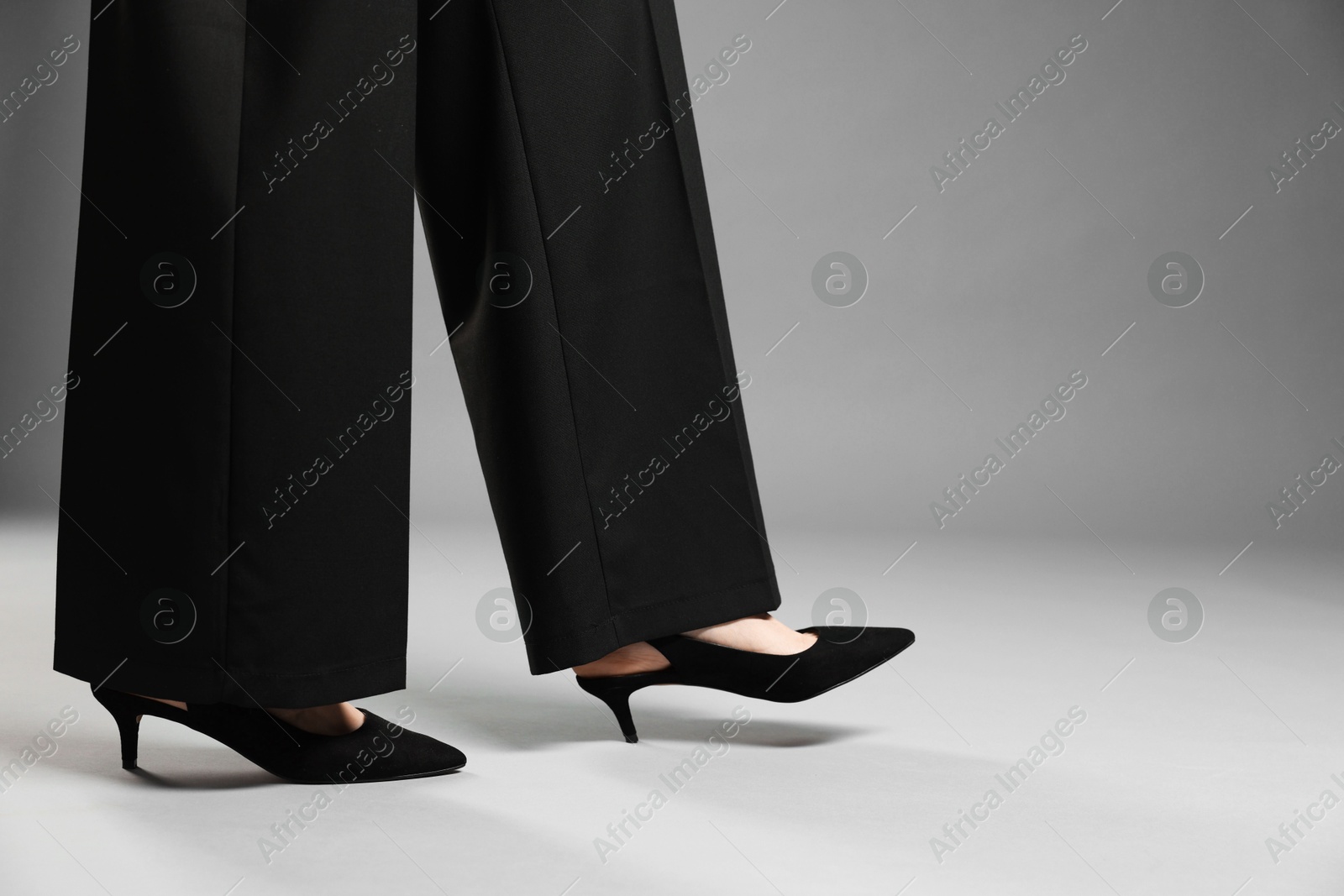 Businesswoman in high heeled shoes on gray background, closeup. Space for text Photo of Businesswoman in high heeled shoes on gray background, closeup. Space for text