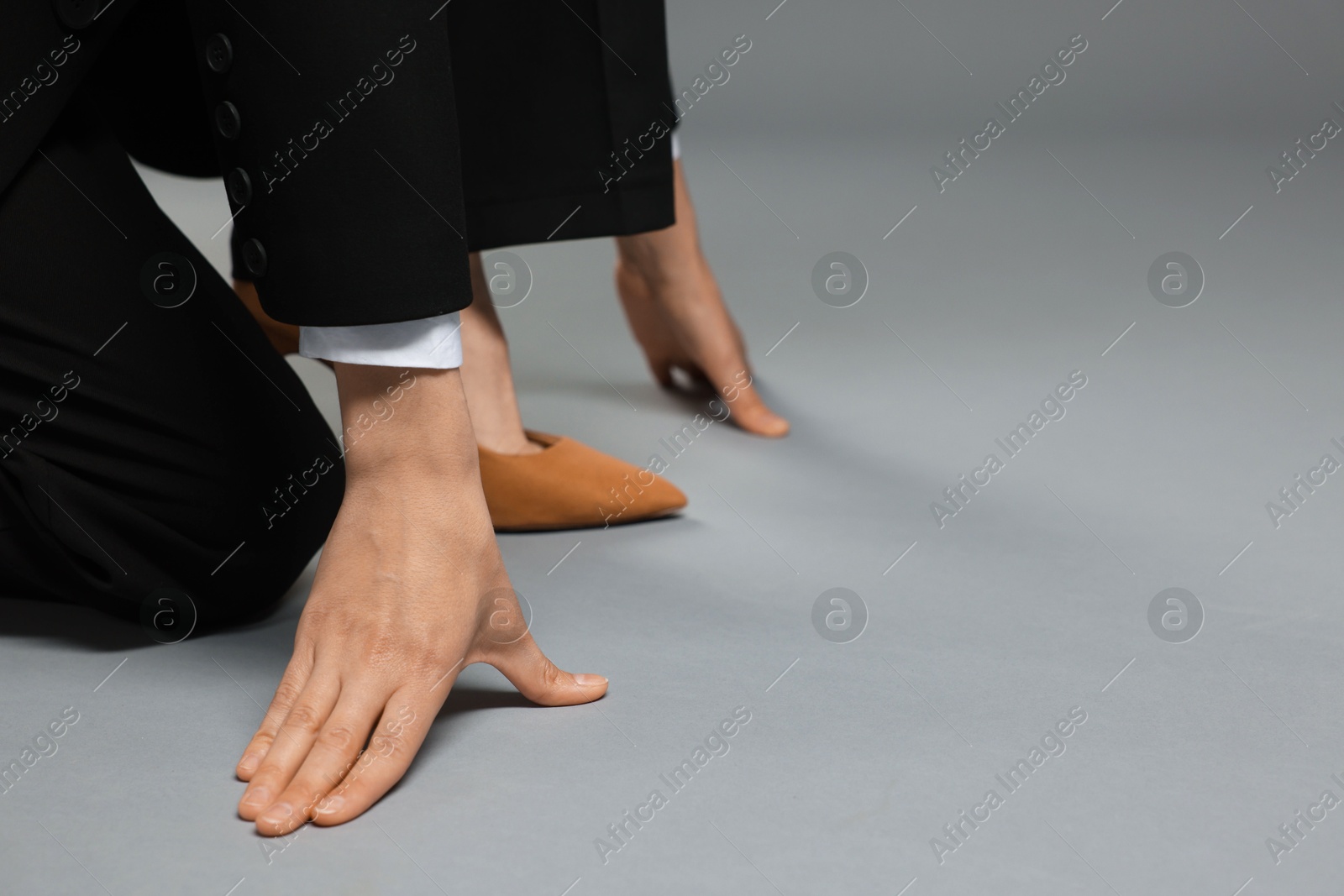 Businesswoman in starting position on gray background, closeup. Space for text Photo of Businesswoman in starting position on gray background, closeup. Space for text
