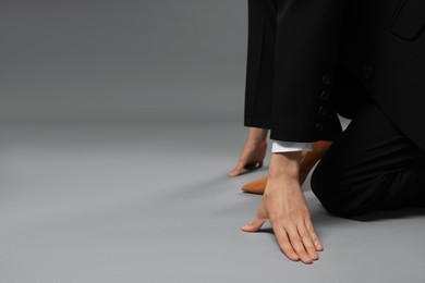 Photo of Businesswoman in starting position on gray background, closeup. Space for text