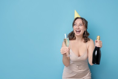 Photo of Birthday celebration. Woman with sparkling wine on light blue background. Space for text
