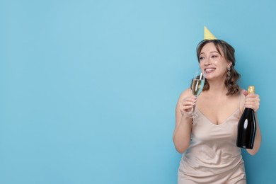 Photo of Birthday celebration. Woman with sparkling wine on light blue background. Space for text