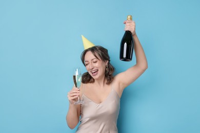 Photo of Birthday celebration. Woman with sparkling wine on light blue background