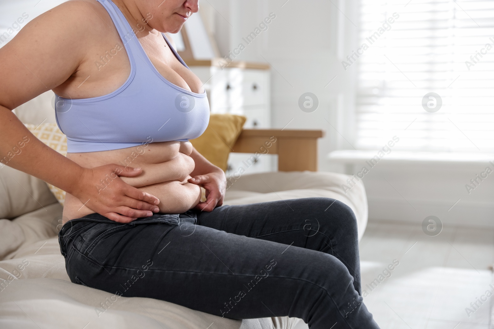 Woman with excessive belly fat at home, closeup and space for text. Overweight problem Photo of Woman with excessive belly fat at home, closeup and space for text. Overweight problem