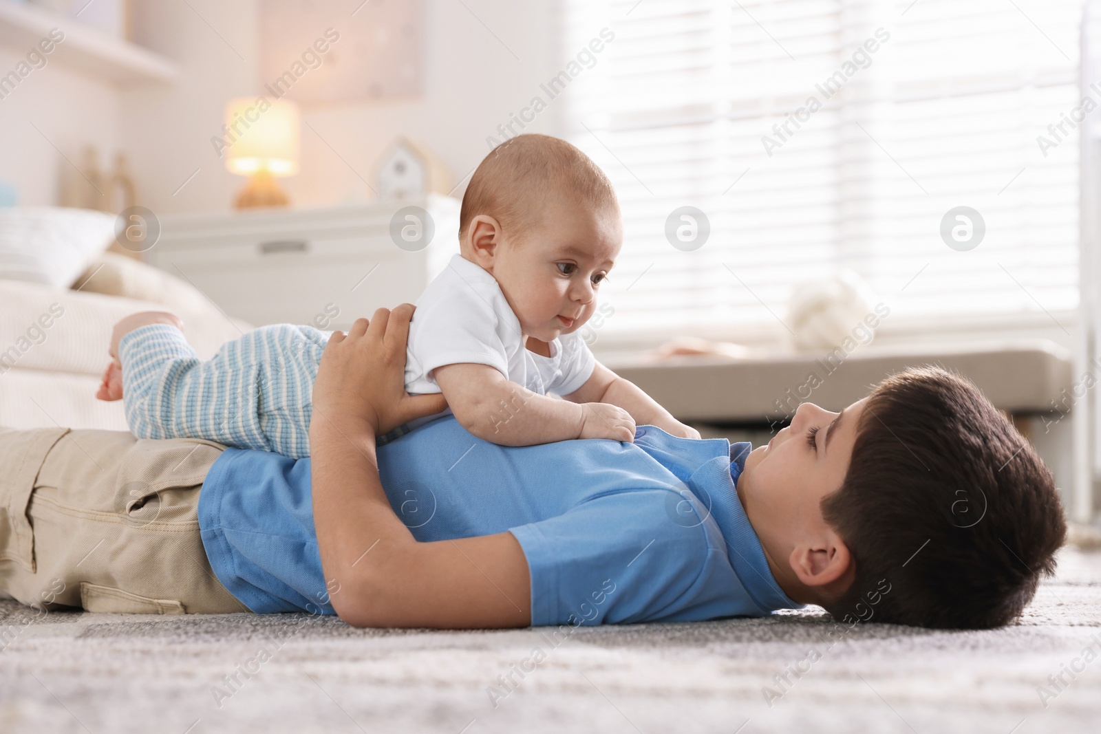 Cute little brothers on floor at home Photo of Cute little brothers on floor at home