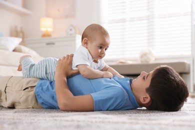 Photo of Cute little brothers on floor at home