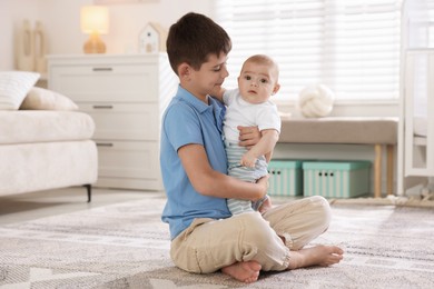 Photo of Cute little brothers hugging on floor at home