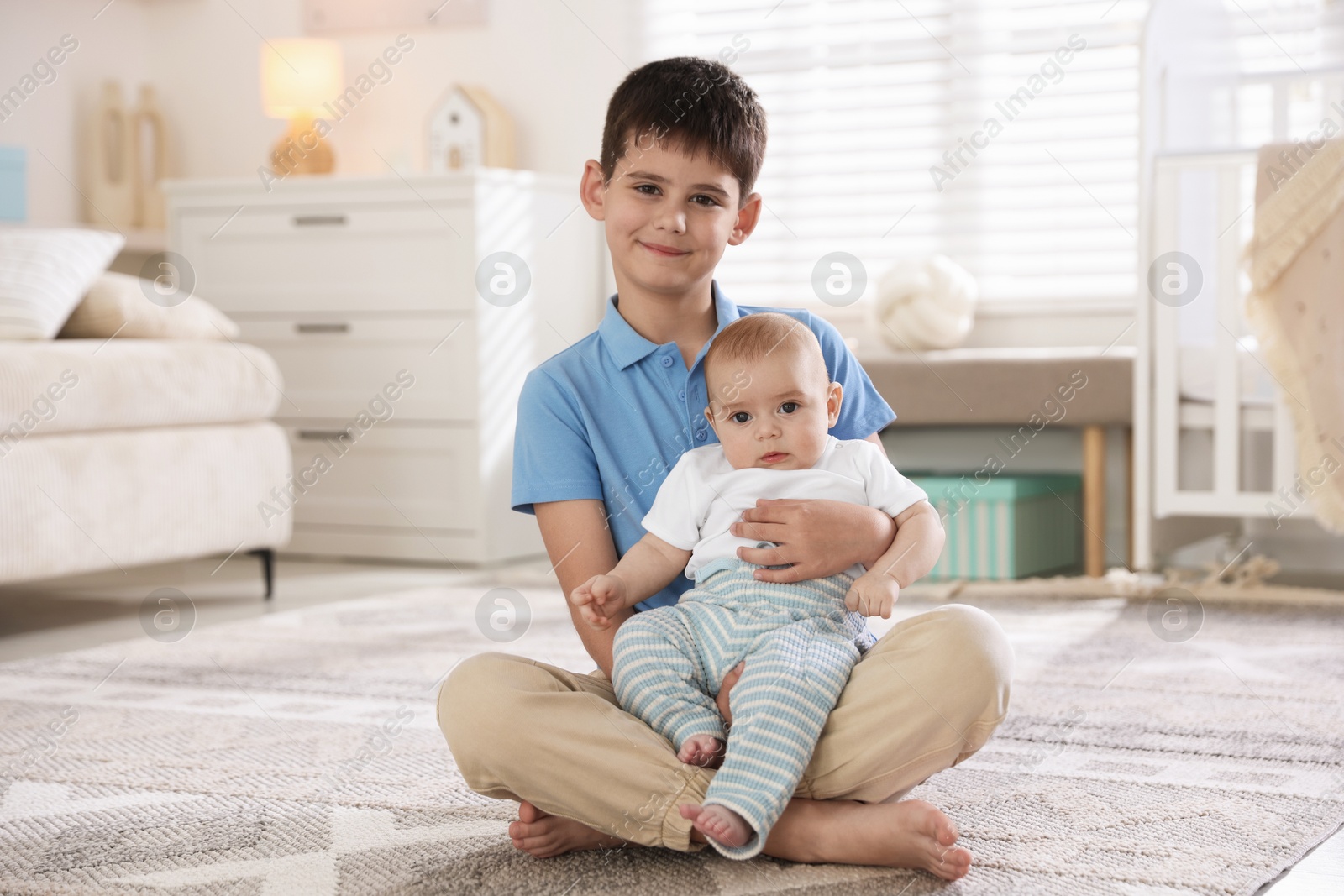 Cute little brothers sitting on floor at home Photo of Cute little brothers sitting on floor at home