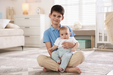 Photo of Cute little brothers sitting on floor at home