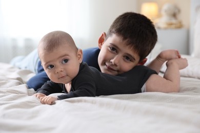 Photo of Cute little brothers on bed at home