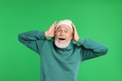 Photo of Elderly man in stylish outfit on green background