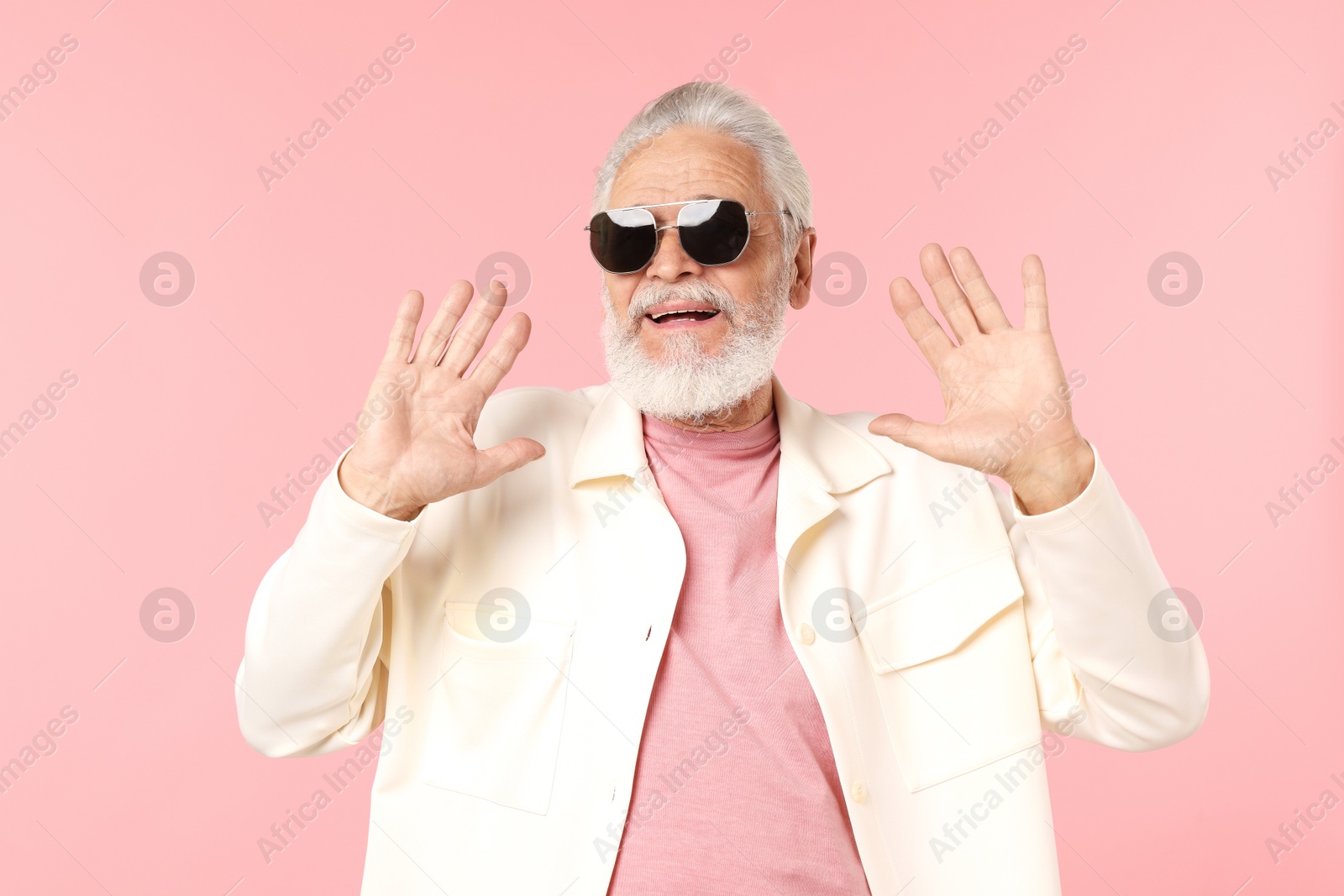 Elderly man in stylish outfit on pink background Photo of Elderly man in stylish outfit on pink background