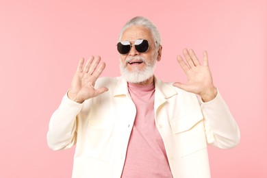 Photo of Elderly man in stylish outfit on pink background