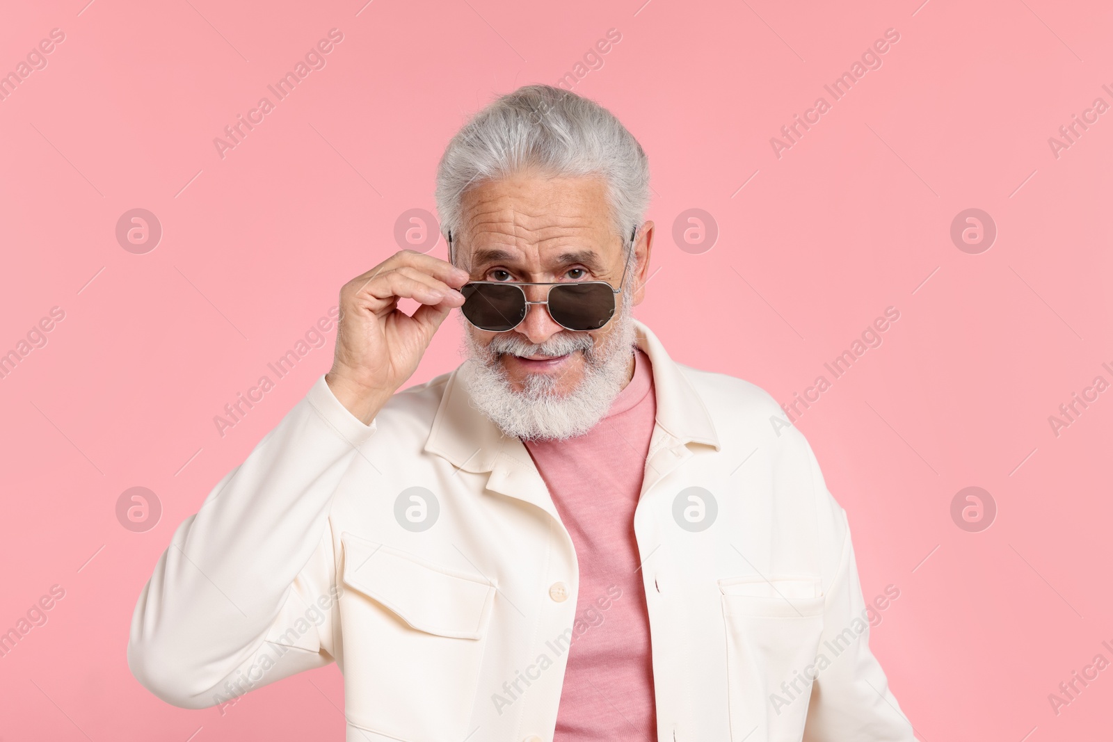 Elderly man in stylish outfit on pink background Photo of Elderly man in stylish outfit on pink background