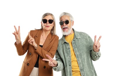 Photo of Senior couple in stylish outfits showing V-signs on white background