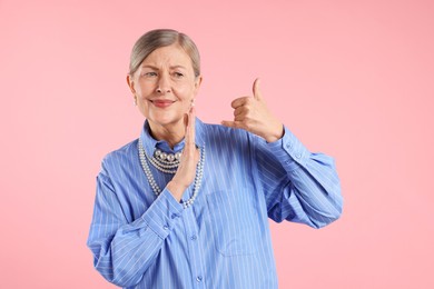 Photo of Senior woman wearing elegant pearl jewelry on pink background