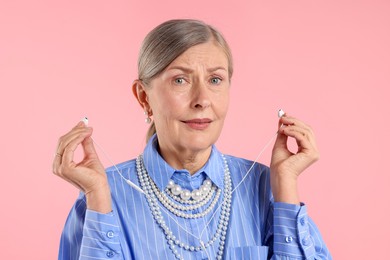 Photo of Senior woman with earphones on pink background