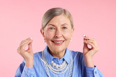 Photo of Senior woman with earphones on pink background