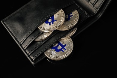 Photo of Cryptocurrency. Bitcoins in wallet on black mirror surface, above view