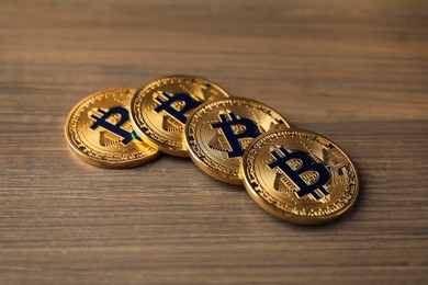 Photo of Cryptocurrency. Many bitcoins on wooden table, closeup