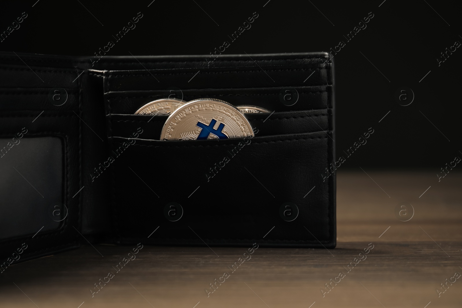 Cryptocurrency. Bitcoins in wallet on wooden background, closeup Photo of Cryptocurrency. Bitcoins in wallet on wooden background, closeup