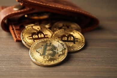 Photo of Cryptocurrency. Bitcoins and wallet on wooden background, closeup