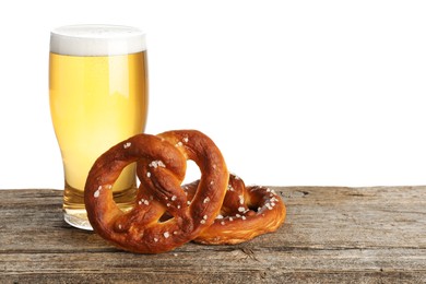 Photo of Tasty pretzels and glass of beer on wooden table against white background. Space for text