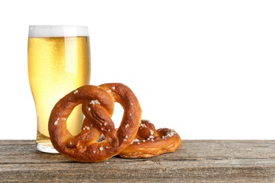 Photo of Tasty pretzels and glass of beer on wooden table against white background. Space for text