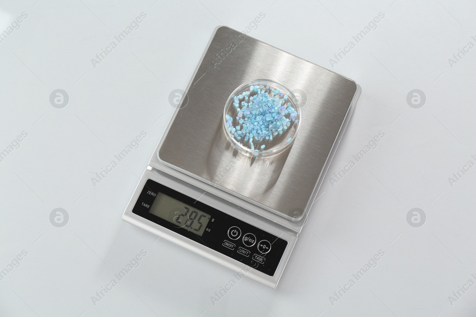 Scale with Petri dish of sample on white table, top view Photo of Scale with Petri dish of sample on white table, top view