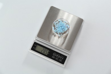 Photo of Scale with Petri dish of sample on white table, top view