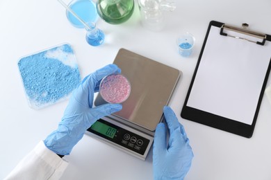 Photo of Scientist working with Petri dish of sample and scales at white table, top view