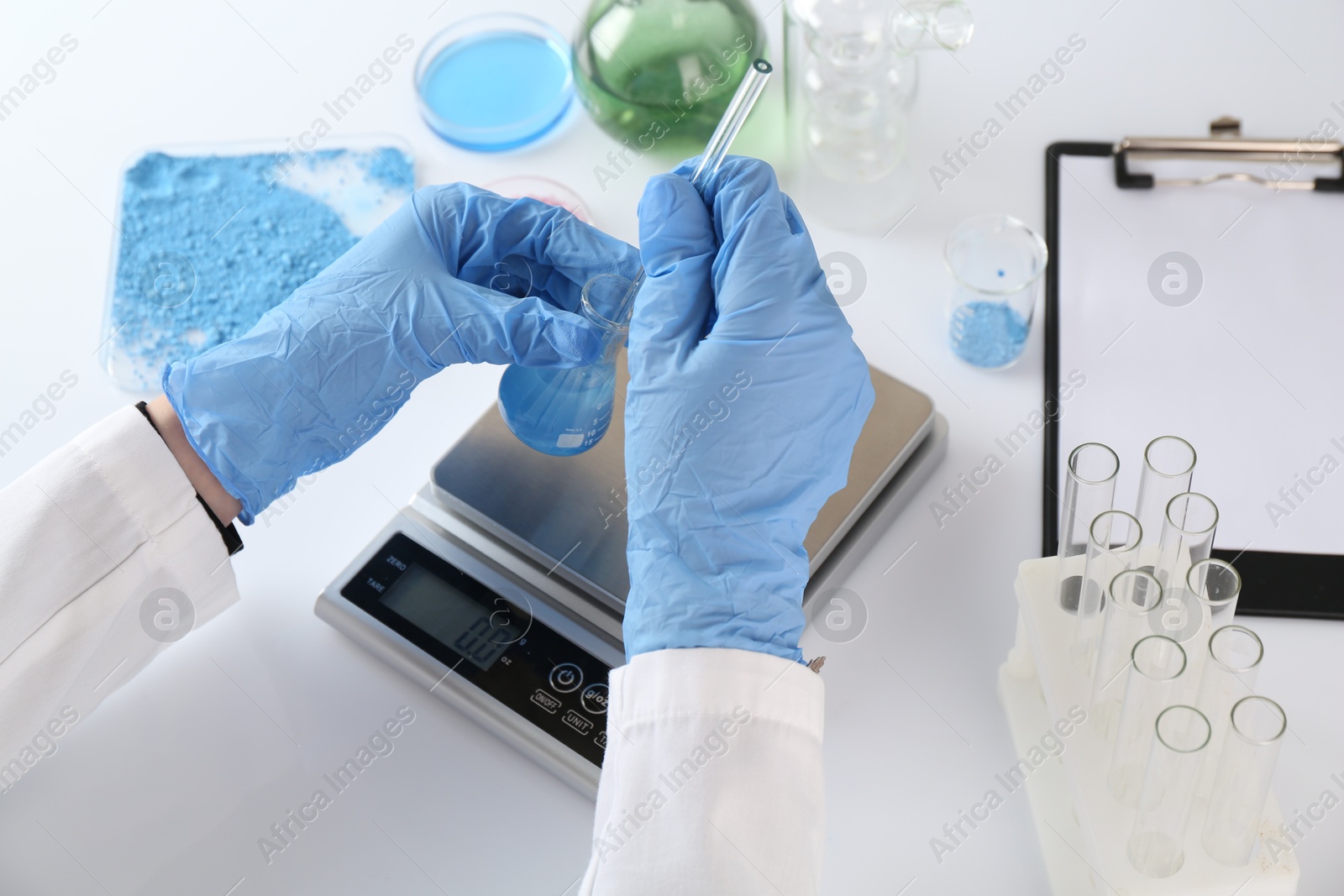 Scientist working with sample and scales at white table, closeup Photo of Scientist working with sample and scales at white table, closeup