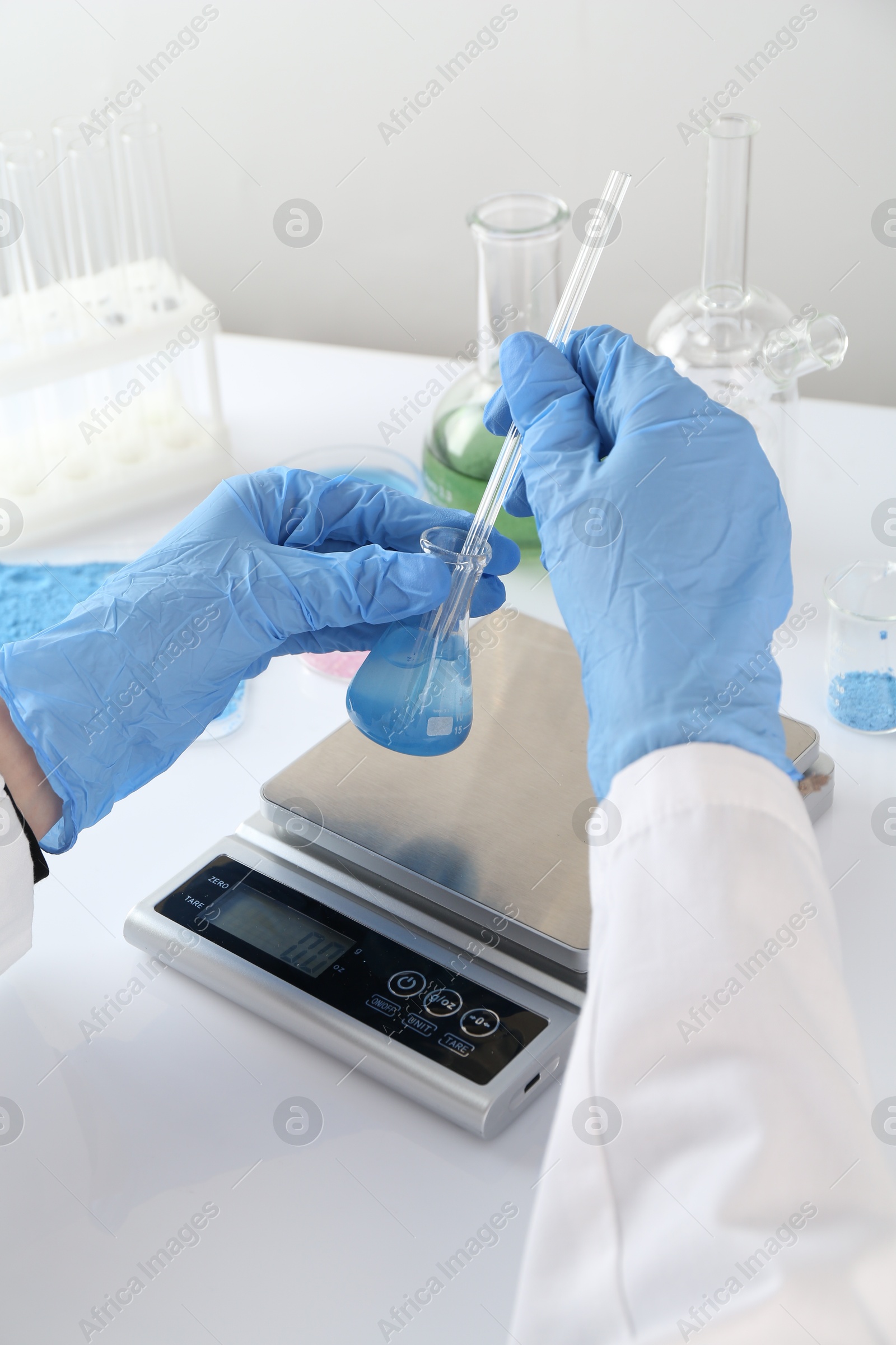 Scientist working with sample and scales at white table, closeup Photo of Scientist working with sample and scales at white table, closeup