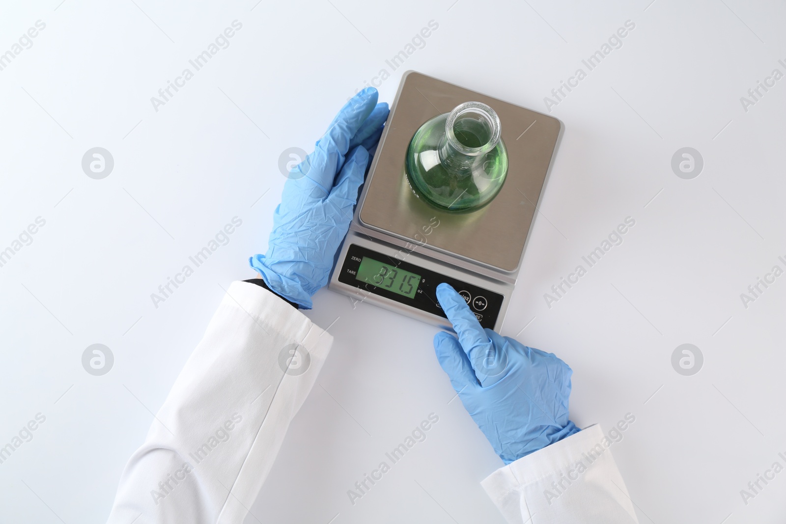 Scientist weighing sample on scales at white table, top view Photo of Scientist weighing sample on scales at white table, top view