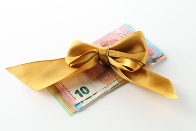 Photo of Money bonus. Euro banknotes with bow on white background