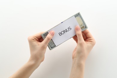 Photo of Woman holding dollar banknotes and card with word Bonus on white background, closeup