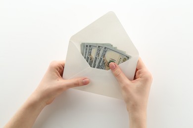 Photo of Money bonus. Woman holding envelope with dollar banknotes on white background, closeup