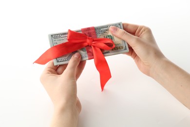 Photo of Money bonus. Woman holding dollar banknotes with bow on white background, closeup