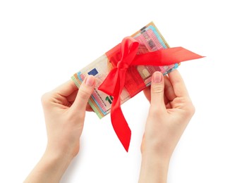 Photo of Money bonus. Woman holding euro banknotes with bow on white background, closeup