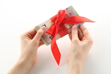 Photo of Money bonus. Woman holding euro banknotes with bow on white background, closeup