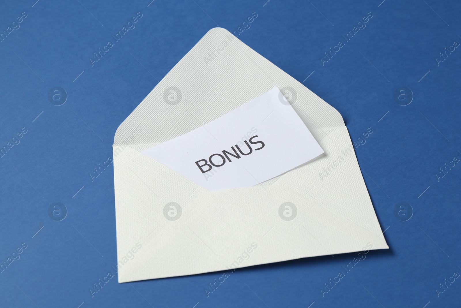 Envelope with word Bonus on blue background Photo of Envelope with word Bonus on blue background