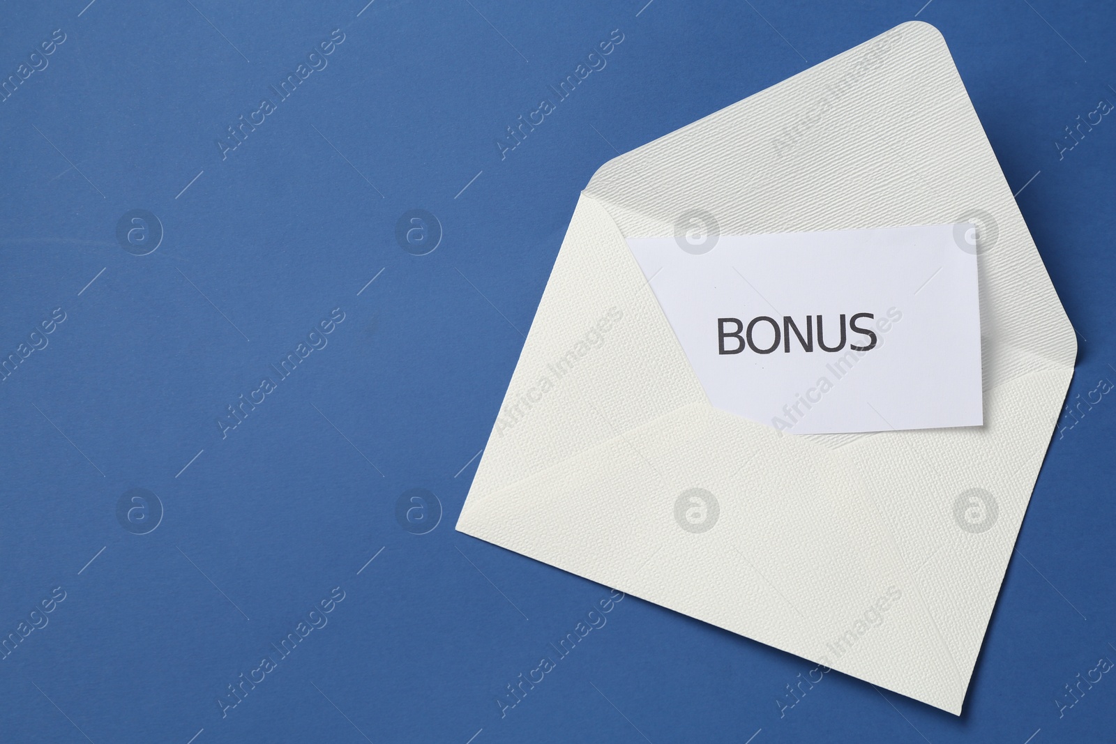 Envelope with word Bonus on blue background, top view. Space for text Photo of Envelope with word Bonus on blue background, top view. Space for text
