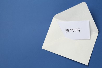 Photo of Envelope with word Bonus on blue background, top view. Space for text