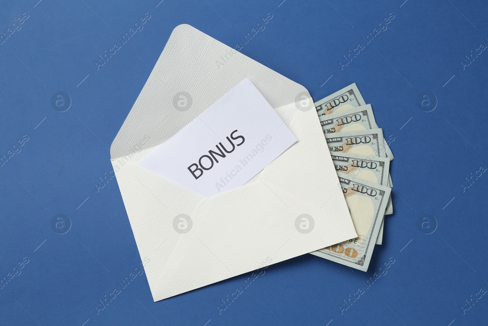 Photo of Envelope with money and word Bonus on blue background, top view