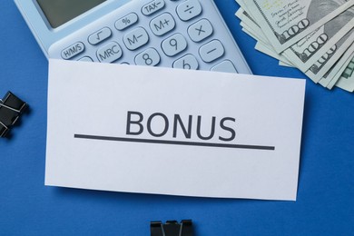 Photo of Card with word Bonus, money, calculator and clips on blue background, flat lay