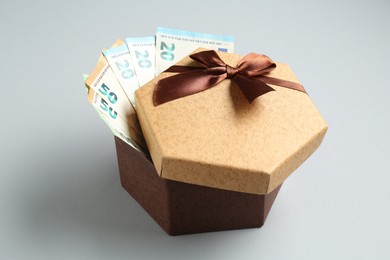 Photo of Money bonus. Gift box with euro banknotes on light grey background