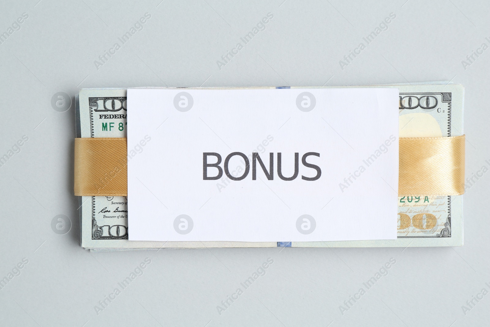 Dollar banknotes and card with word Bonus on light grey background, top view Photo of Dollar banknotes and card with word Bonus on light grey background, top view
